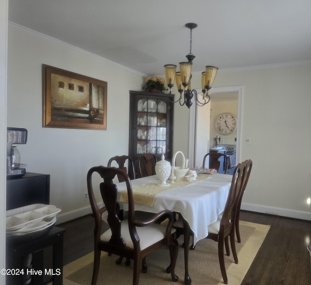 dining area with crown molding, dark wood-type flooring, and a chandelier