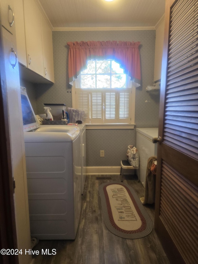 laundry room with dark hardwood / wood-style floors, cabinets, crown molding, and washing machine and dryer