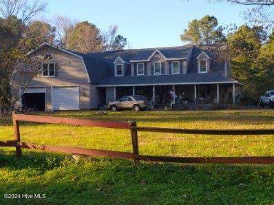 new england style home with a garage and a front lawn