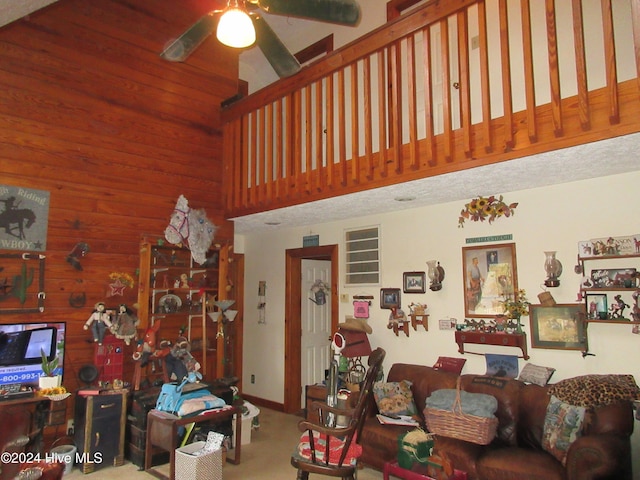 living room featuring carpet flooring, ceiling fan, and wooden walls