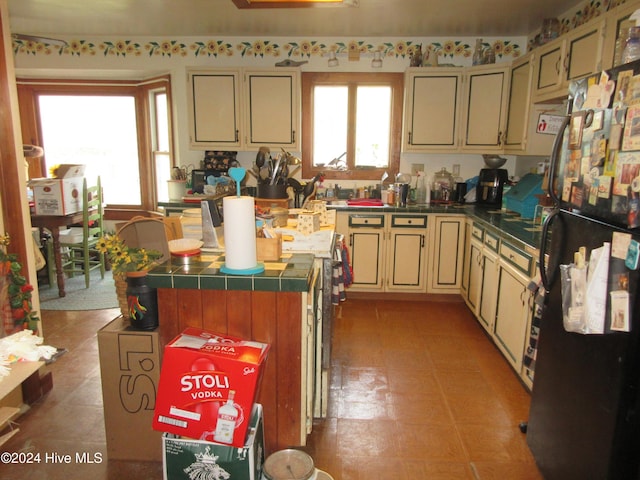 kitchen featuring a center island, cream cabinets, and fridge