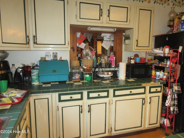 kitchen featuring tile counters and cream cabinetry