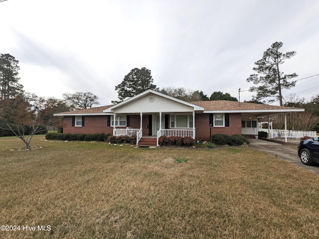 single story home featuring covered porch, a front yard, and a carport