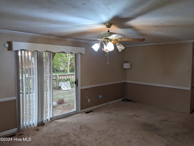 carpeted spare room with crown molding and ceiling fan