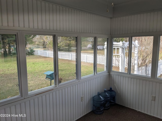 unfurnished sunroom featuring a water view