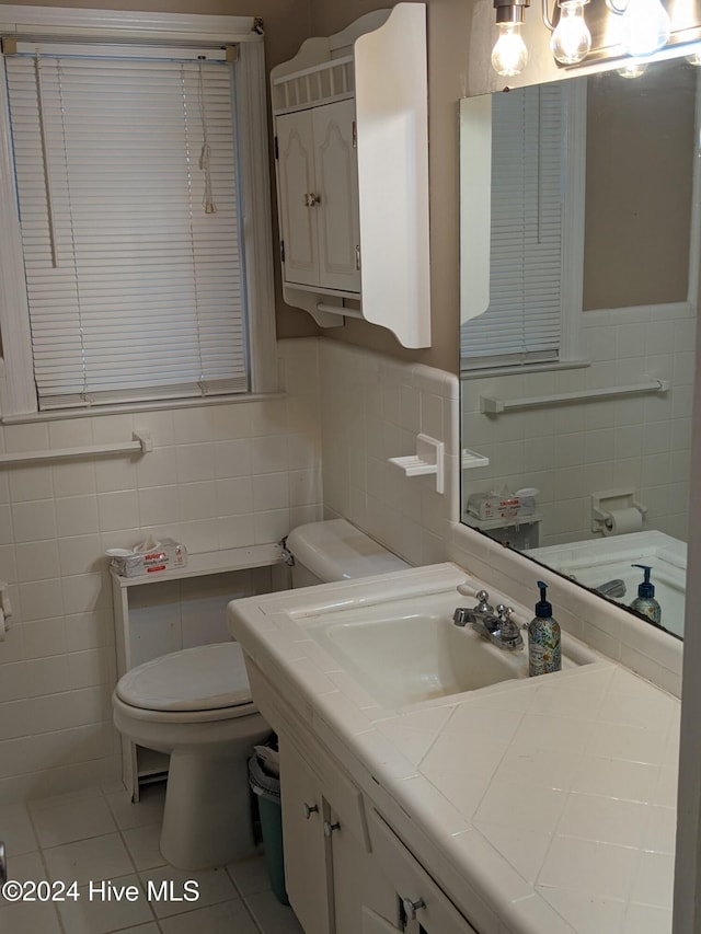 bathroom with tile patterned flooring, vanity, toilet, and tile walls