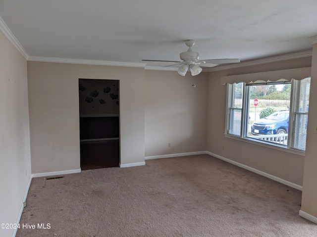 carpeted spare room featuring ceiling fan and ornamental molding