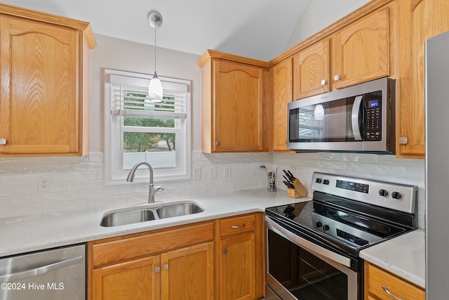 kitchen with decorative backsplash, appliances with stainless steel finishes, sink, pendant lighting, and lofted ceiling