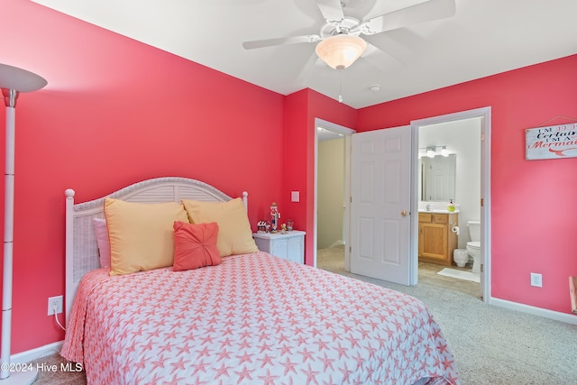 carpeted bedroom featuring ensuite bath, ceiling fan, and sink