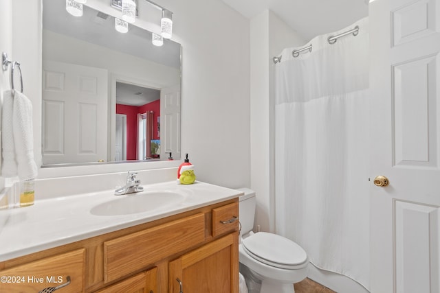 bathroom featuring vanity, toilet, and walk in shower