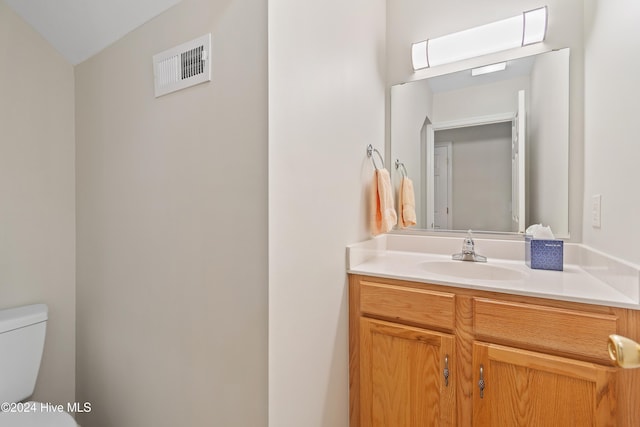 bathroom featuring vanity, toilet, and lofted ceiling