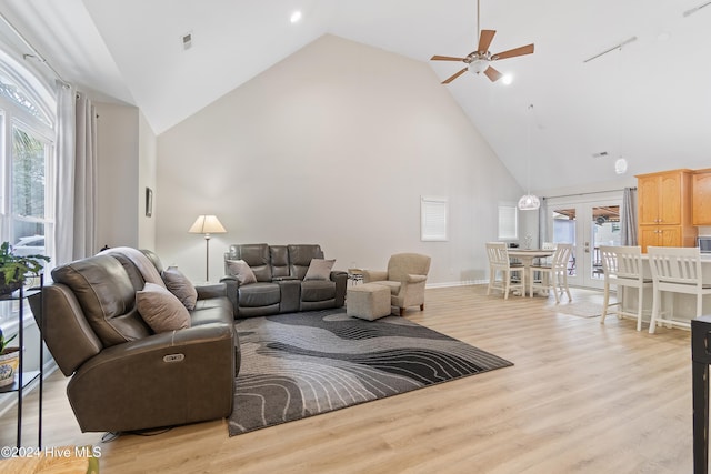 living room with a wealth of natural light, ceiling fan, high vaulted ceiling, and light hardwood / wood-style flooring