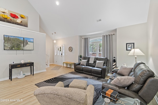 living room with high vaulted ceiling and light hardwood / wood-style flooring