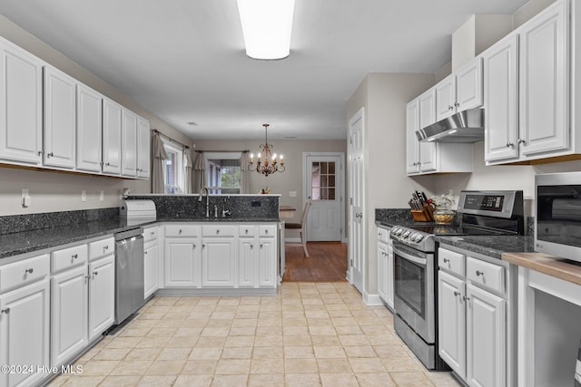 kitchen with appliances with stainless steel finishes, sink, decorative light fixtures, a notable chandelier, and white cabinetry