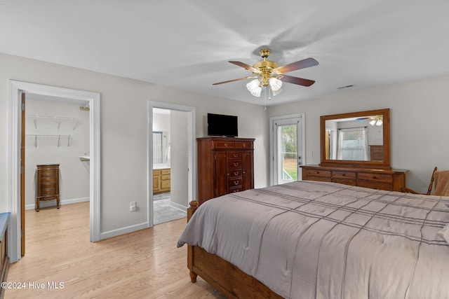 bedroom featuring ceiling fan, ensuite bathroom, light hardwood / wood-style floors, a walk in closet, and a closet