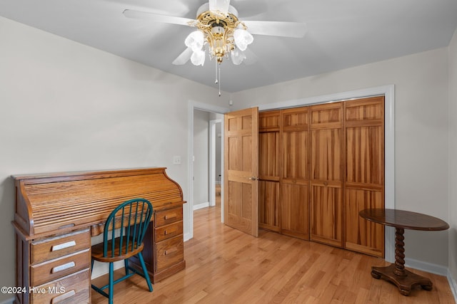 office with light wood-type flooring and ceiling fan