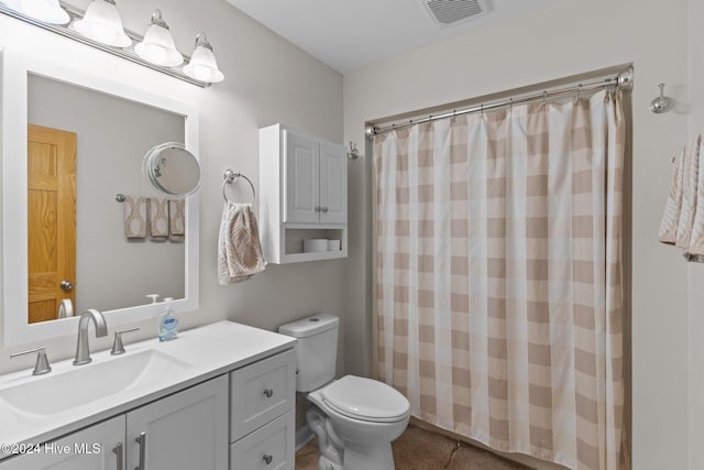 bathroom with a shower with shower curtain, vanity, toilet, and tile patterned floors