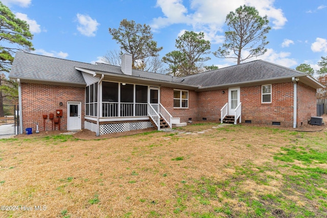 rear view of house with central AC unit and a yard