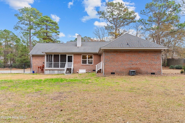 back of property featuring a sunroom and a yard