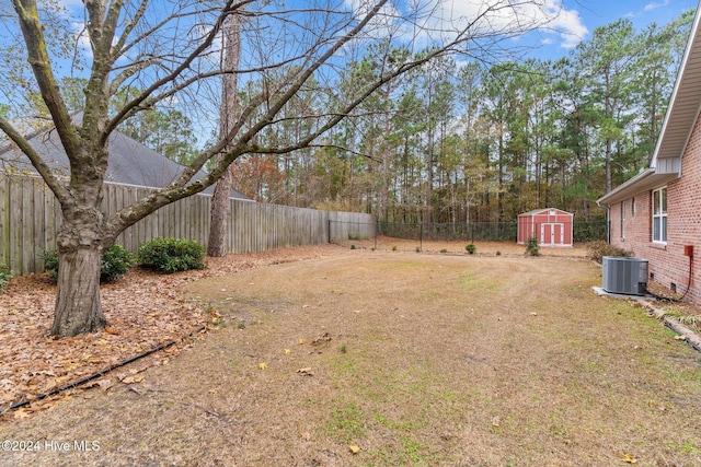 view of yard with central AC unit and a storage unit