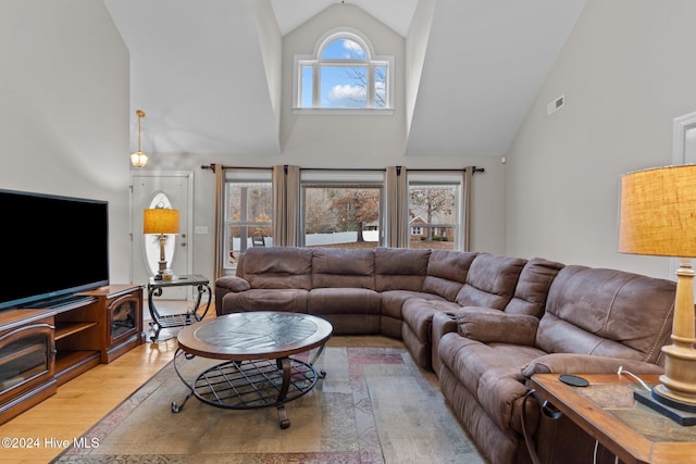 living room featuring light hardwood / wood-style floors and high vaulted ceiling