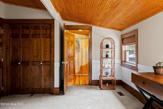 interior space with vaulted ceiling, wood ceiling, crown molding, and carpet floors