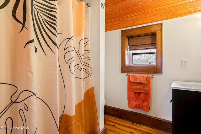 bathroom featuring hardwood / wood-style flooring, vanity, curtained shower, and wood ceiling