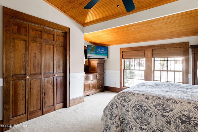 bedroom with wood ceiling, light colored carpet, a closet, and ceiling fan