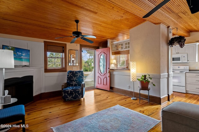 living room with ceiling fan, sink, light hardwood / wood-style floors, and wooden ceiling