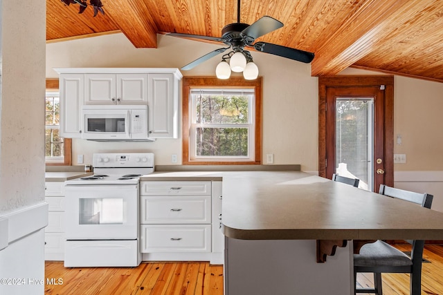 kitchen with white appliances, lofted ceiling with beams, white cabinets, a kitchen bar, and kitchen peninsula