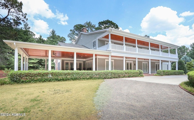 view of front of property featuring a front yard and a balcony