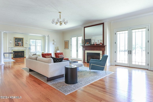 living room with a chandelier, french doors, light hardwood / wood-style flooring, and a wealth of natural light