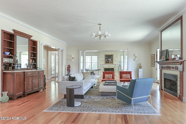 living room with light wood-type flooring, crown molding, and a notable chandelier