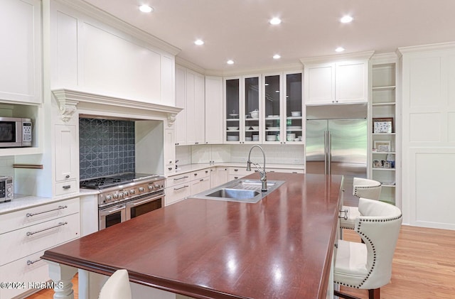 215 Inverrary Rd, Pinehurst, NC 28374 - kitchen with high end appliances, a kitchen island with sink, a breakfast bar, tasteful backsplash, and recessed lighting