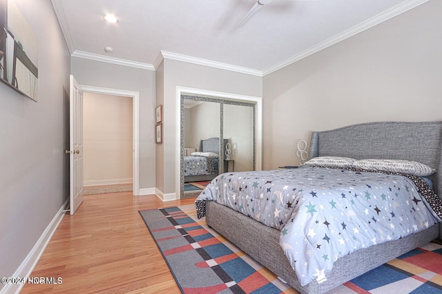 bedroom featuring a closet, hardwood / wood-style flooring, ceiling fan, and ornamental molding