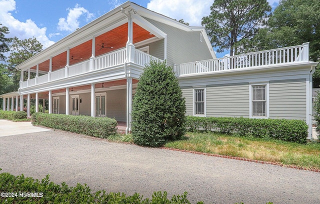 view of side of home featuring ceiling fan and a balcony