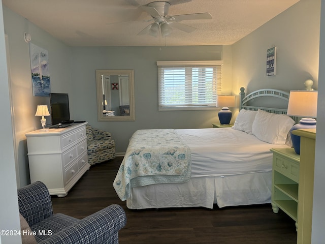 bedroom with a textured ceiling, dark hardwood / wood-style floors, and ceiling fan