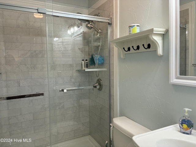 bathroom featuring toilet and a shower with shower door