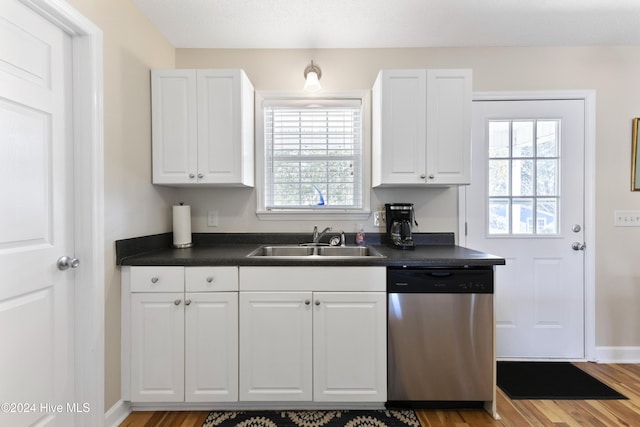 kitchen with white cabinets, light hardwood / wood-style floors, stainless steel dishwasher, and sink