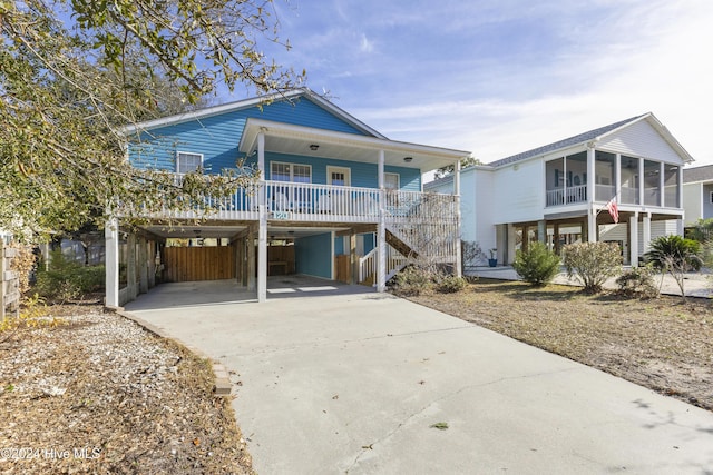 view of front facade featuring a carport, a sunroom, and covered porch