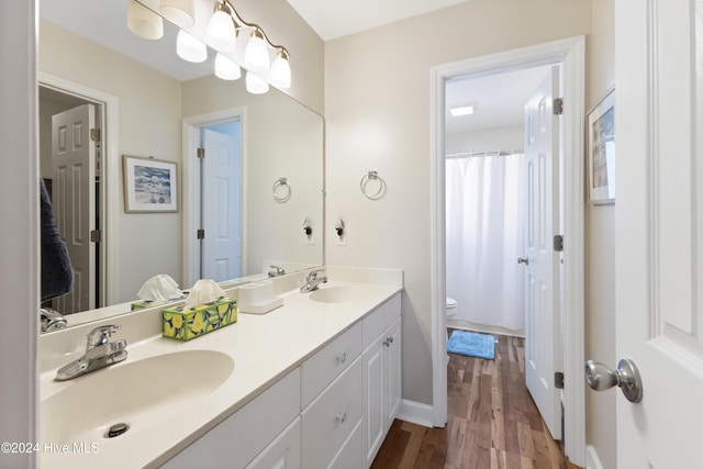 bathroom featuring vanity, hardwood / wood-style flooring, and toilet