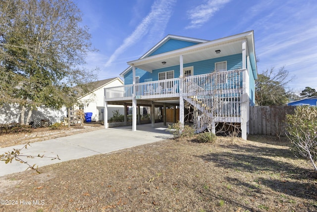 back of property with a carport and covered porch