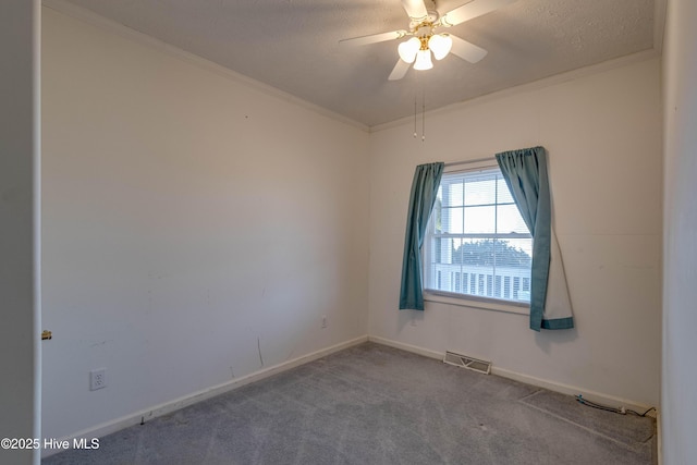 carpeted spare room with ceiling fan, a textured ceiling, and ornamental molding