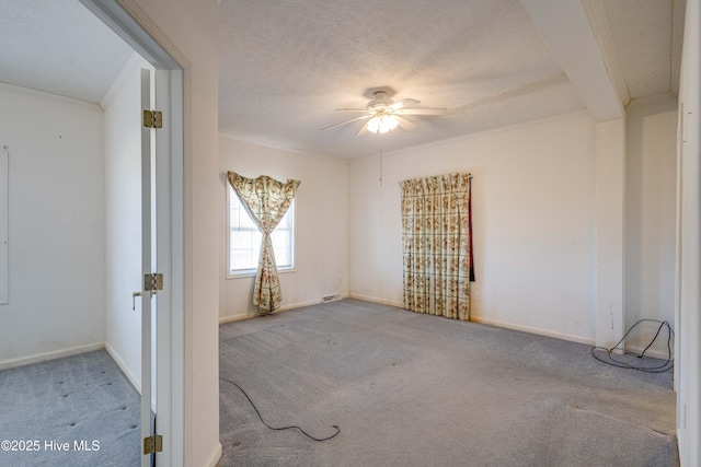 carpeted spare room featuring ceiling fan and a textured ceiling