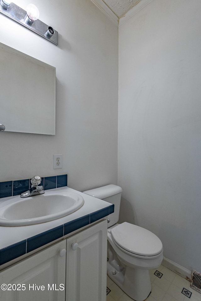 bathroom featuring vanity, toilet, and crown molding