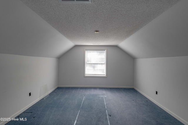 bonus room with dark carpet, a textured ceiling, and vaulted ceiling