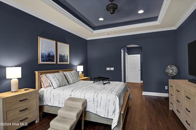 bedroom with ceiling fan, a raised ceiling, crown molding, and dark hardwood / wood-style floors