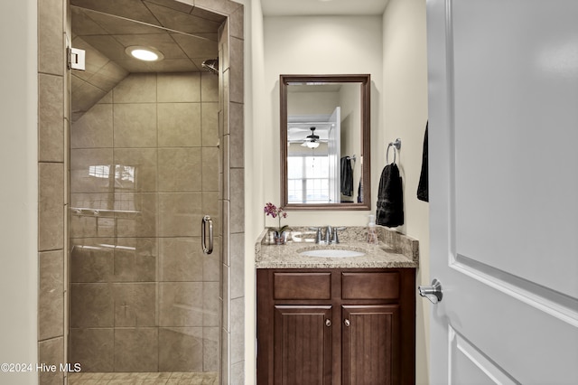 bathroom with a shower with door and vanity