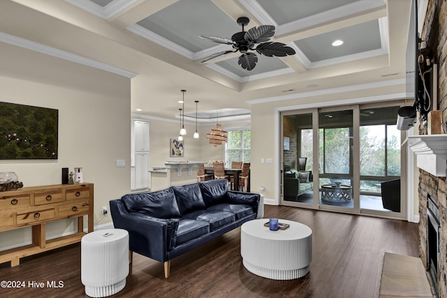 living room featuring a stone fireplace, coffered ceiling, beam ceiling, ornamental molding, and dark hardwood / wood-style flooring