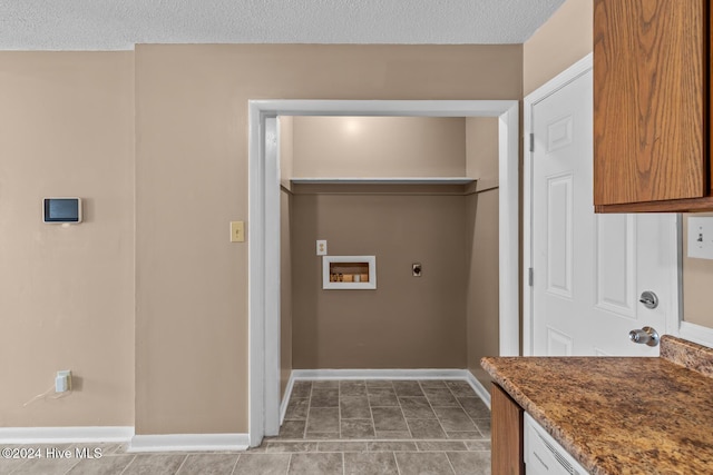 clothes washing area with washer hookup, a textured ceiling, tile patterned floors, and electric dryer hookup